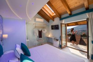 阿杰罗拉Donna Sofi Holiday House的一间带紫色床的卧室和一个阳台