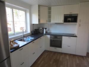 ArbråTORPET (Villa Solsidan), Hälsingland, Sweden的厨房配有白色橱柜、水槽和窗户。