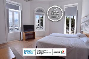 奥尔塔Internacional Azores Boutique的一间卧室设有一张床、一台电视和窗户。