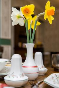 霍利All Seasons Gatwick Guest House & Parking的一组花瓶,在桌子上放着鲜花