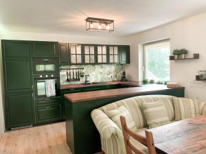 罗塞格Appartamento Giovanna Rosegg的绿色的厨房配有沙发和桌子