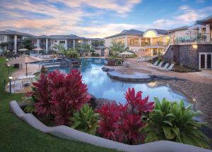 普林斯维尔Club Wyndham Bali Hai Villas的拥有红色植物的大型游泳池的度假酒店