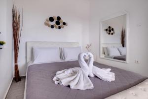 Éxo GoniáBlue Soul Luxury Villa的卧室里床边的两只天鹅