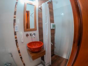 奥韦拉Hotel Cuatro Pinos的一间带红色水槽和镜子的浴室
