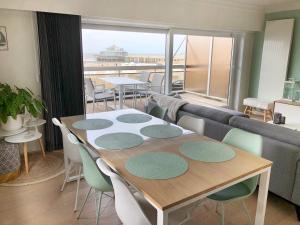 布兰肯贝赫Luxueus appartement met ruim terras, frontaal zeezicht 4 à 5 personen的一间带桌椅和沙发的用餐室