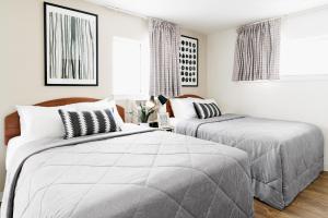诺福克InTown Suites Extended Stay Norfolk VA的卧室设有2张床和白色的墙壁。