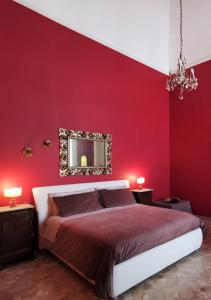 莱切Chez Moi Charme B&B的红色卧室配有床和镜子
