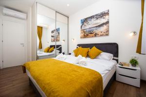 布德瓦Milara Apartments的一间卧室配有一张带黄色毯子的大床