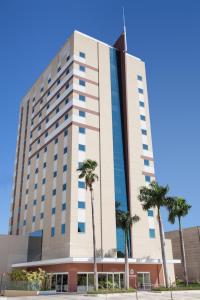 库亚巴代尔蒙酒店的一座高大的建筑,前面有棕榈树