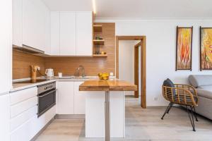 特罗亚TRÓIA BOUTIQUE APARTMENT的厨房配有白色橱柜和木制台面