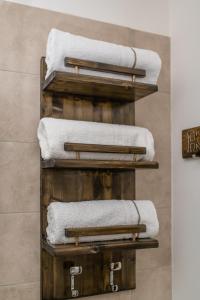 那不勒斯Residenza San Gregorio Armeno的浴室里木架上的毛巾堆