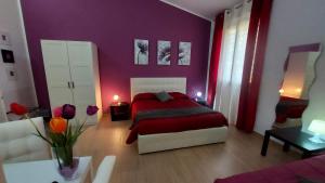 卡拉塔菲米迪塞杰斯塔住宿加早餐旅馆的一间卧室设有一张红色的床和紫色的墙壁