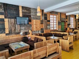 莫克拉戈拉Čarobni Breg的餐厅设有木墙、沙发和桌子