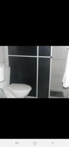 卡内拉Magias da Serra的浴室设有白色卫生间和黑色墙壁。