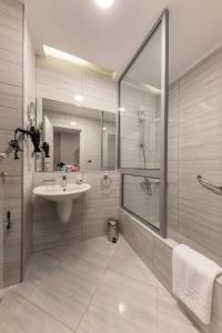 十月六日城Royal Day Plaza Hotel的一间带水槽、淋浴和镜子的浴室
