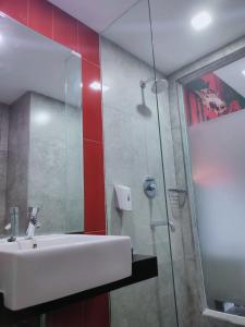 KebumenGrand Kolopaking Hotel的一间带水槽和玻璃淋浴的浴室
