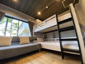 富士河口湖TOCORO. Mt. Fuji Hostel的一间带两张双层床和一张沙发的卧室