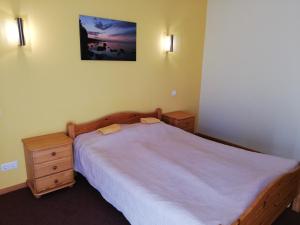 罗亚若德利旅馆的一间卧室配有一张床、梳妆台和一张照片