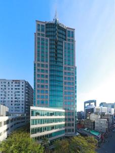 首尔仁寺洞奥拉凯伊公寓式酒店的一座高大的玻璃建筑,在城市里陡峭