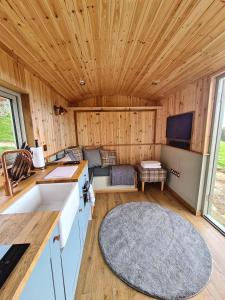 霍普Peak District Shepherds Hut的厨房以及带沙发和电视的客厅。