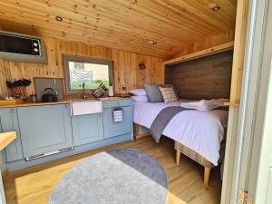 霍普Peak District Shepherds Hut的小屋内设有一间带床铺的卧室和厨房