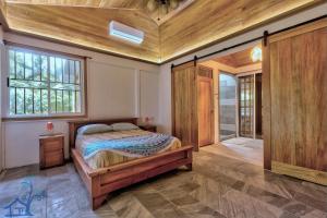 蓬塔乌巴Our Beachfront Bungalow的一间卧室设有一张床和木制天花板