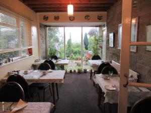 伊尔弗勒科姆Avoncourt Lodge的餐厅设有桌椅和大窗户。