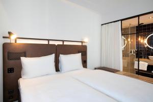 布达佩斯H2 Hotel Budapest的卧室设有白色的床和大窗户