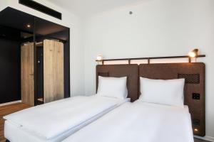 布达佩斯H2 Hotel Budapest的配有白色床单的客房内的两张床