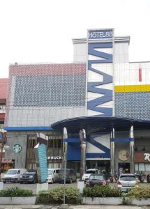 班贾尔马辛Hotel 88 Banjarmasin By WH的停车场内有车辆的建筑物