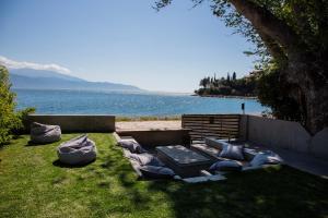 纳弗帕克托斯Spa Villa Skaloma的一组枕头坐在水边的草地上