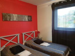 波讷地区帕朗提Laouchet Le Hameau des Grands Lacs的宿舍间的两张床,设有红色的墙壁和窗户。