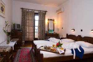 斯科派洛斯迪奥尼索斯酒店的酒店客房设有两张床和一盘食物