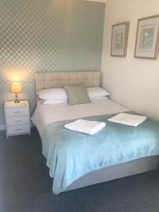 阿博波恩Rooms at The Highcliffe的一间卧室配有一张床,上面有两条毛巾