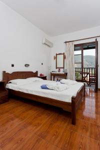 斯科派洛斯迪奥尼索斯酒店的铺有木地板的客房内一张大床