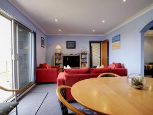 坦卡里Anchorage 7的客厅配有红色的沙发和木桌