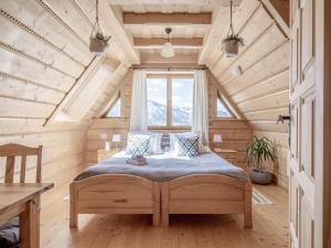 考斯赛力克Wierchowa Chata的木制客房内的一间卧室,配有一张床