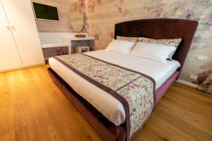 维托里奥·威尼托Relais Althea Azienda Agrituristica的一间卧室配有一张大床和木制床头板