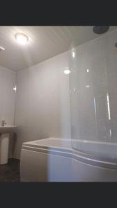 卡尔顿骏马湾旅馆的白色的浴室设有浴缸和水槽。