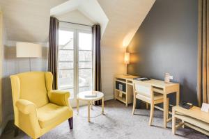 维利耶维利尔斯马哈城堡酒店的客厅配有黄色椅子和书桌