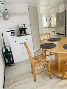 滨海贝尔克Mobil-home 4 personnes 400m de la mer的一间带桌椅的厨房和一间用餐室