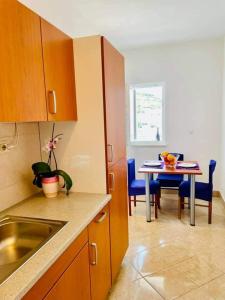 玛里纳Apartman & rooms Draga的厨房配有水槽和桌椅