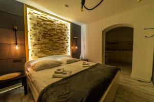 米科瓦伊基Promenada Apartamenty i Domek Nad Jeziorem的一间卧室设有一张带砖墙的大床
