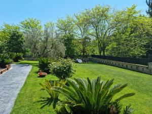 罗马Il Casale nel Parco Guesthouse的一个带栅栏、草和植物的花园