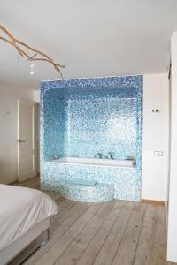 艾默伊登维他命Z住宿加早餐旅馆的浴室配有蓝色瓷砖墙和浴缸
