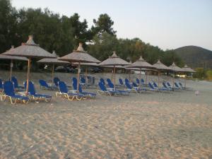 伊里斯斯Eleni Rooms Develiki的海滩上的一组椅子和遮阳伞