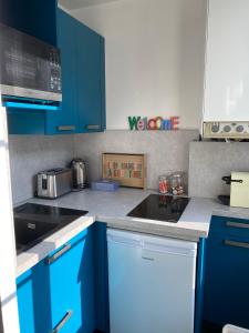 鲁昂Le 4B - Le Tiki的厨房配有蓝色橱柜和水槽