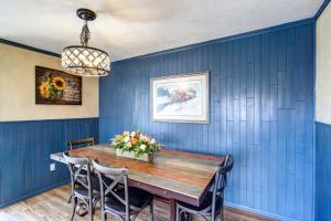 蒙特罗斯Charming Montrose Family Home Block to Downtown!的一间拥有蓝色墙壁和木桌的用餐室