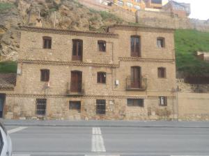 特鲁埃尔Apartamento Bajo Los Arcos的山边的建筑物,靠近公路