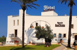 奥斯图尼黎莱斯盛特利吉欧酒店的一座白色的建筑,前面有棕榈树